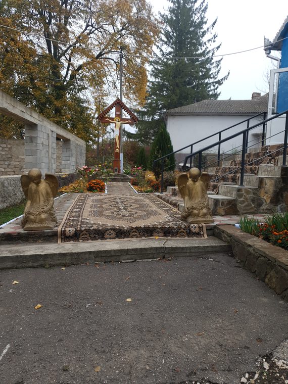 Aleea pavată din ogradă, cu troița în capăt