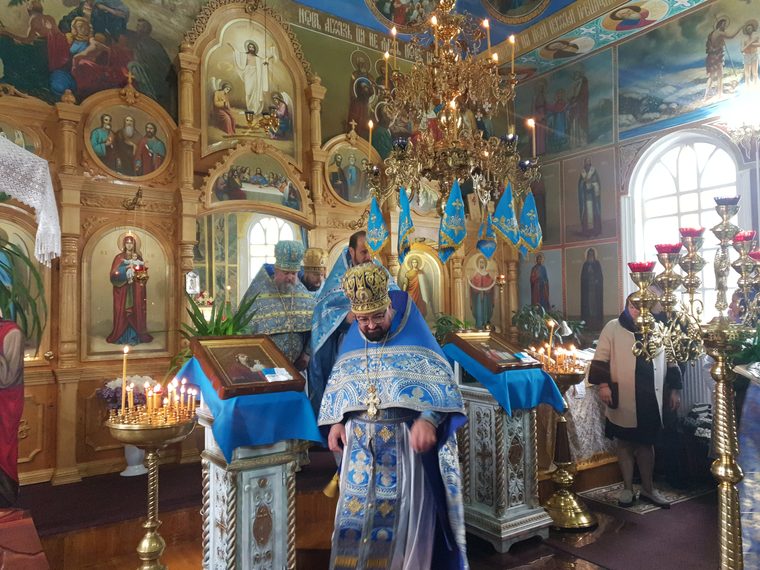 Preot cu mitră, în fața iconostasului