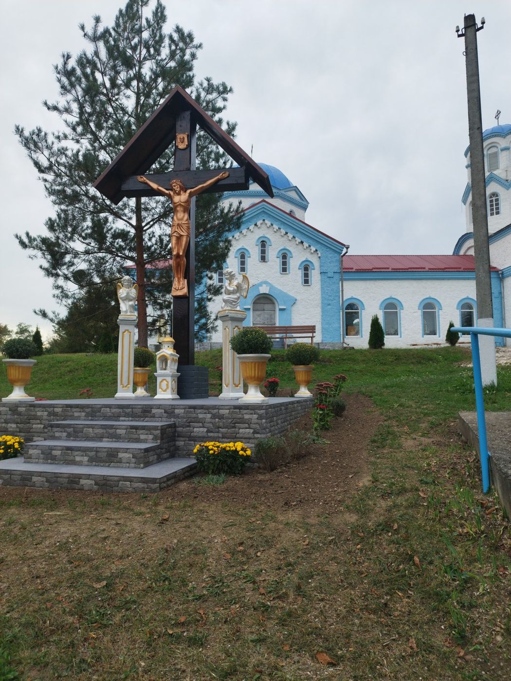 Răstignirea de deasupra văii, dimineața, cu biserica în spate