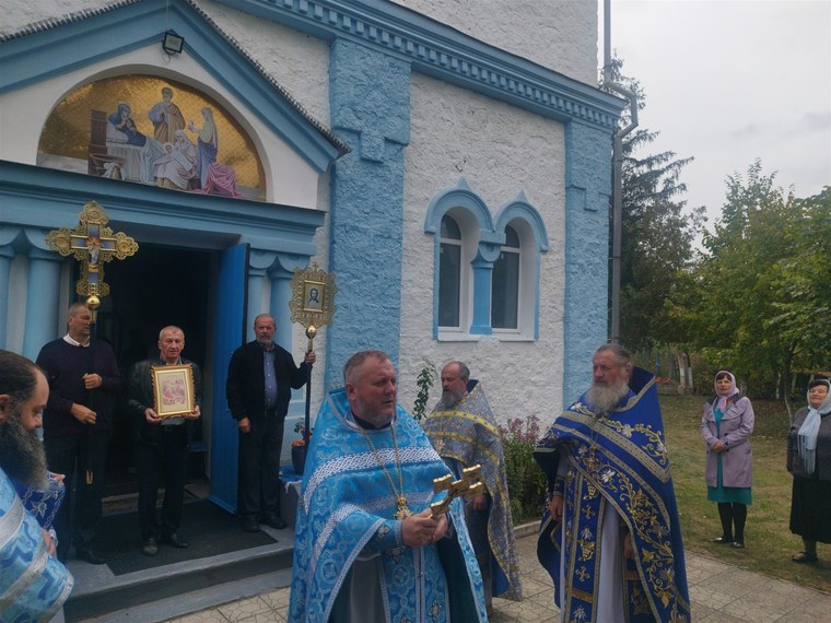 La intrarea bisericii, sub icoana hramului; părintele nostru Valerii, lângă biserică