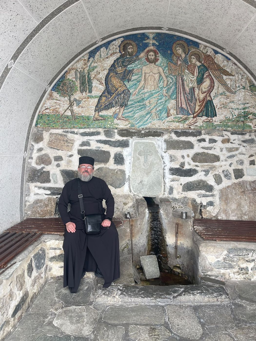 Popas la un izvor sfânt, sub icoana în mozaic a Botezului Domnului