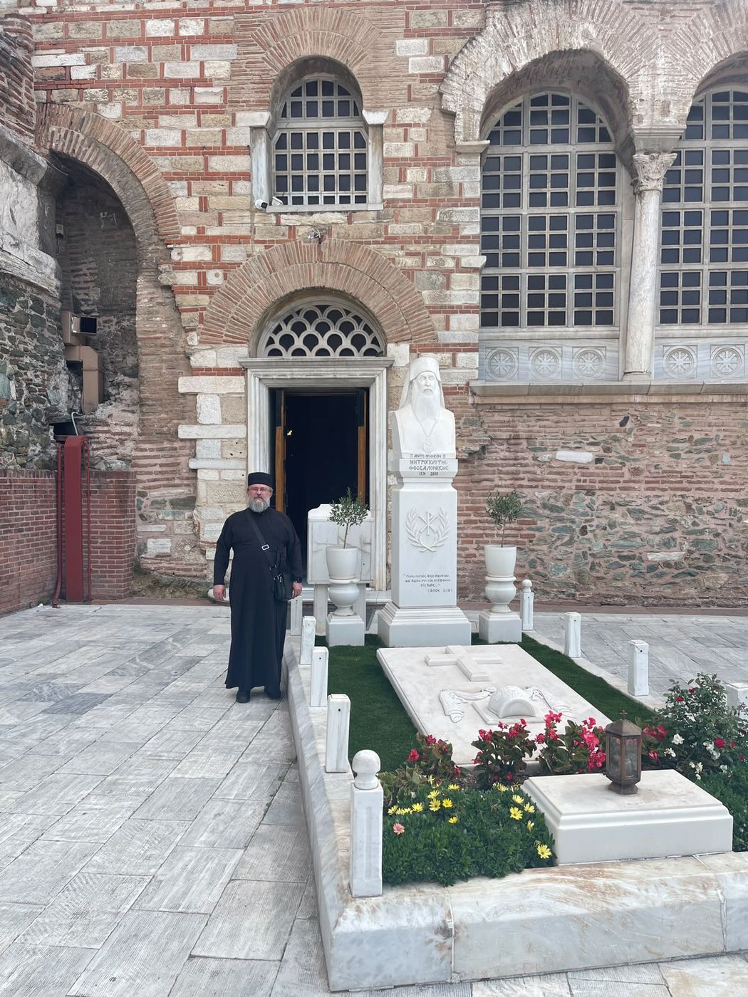 Tesalonic: un mormânt de marmură, cu flori, lângă zidul bisericii